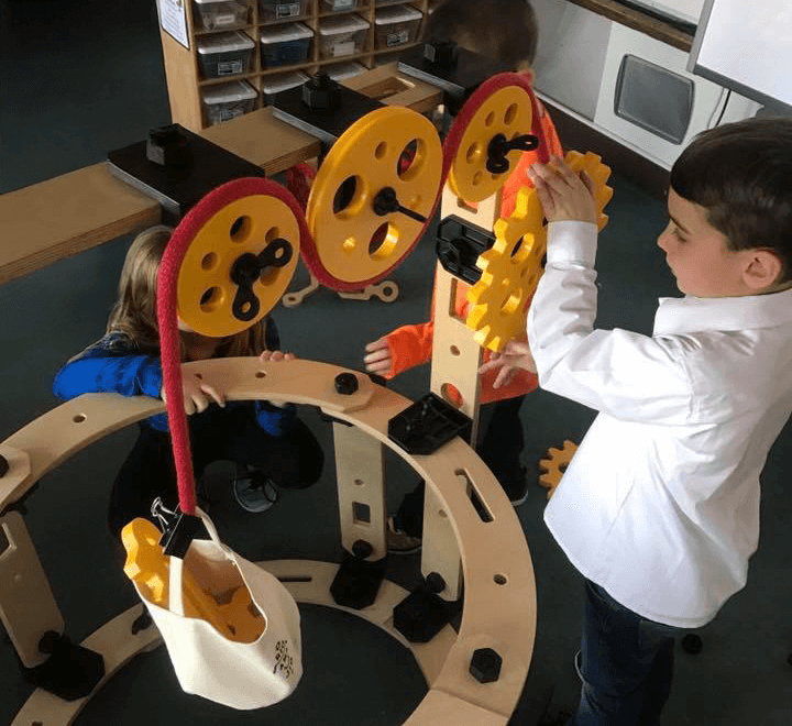Children actively collaborating on Rigamajig invention